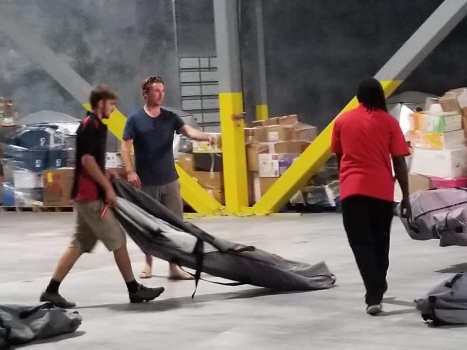 A man in a red shirt is carrying a large bag 28.4845° N, 81.2519° W