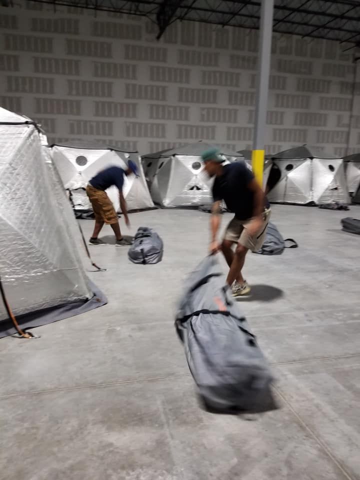 A man is carrying a large bag in a warehouse 28.4845° N, 81.2519° W