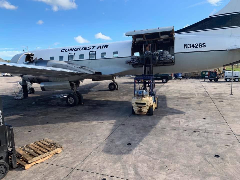 A plane is being loaded with cargo by a forklift. 28.4845° N, 81.2519° W