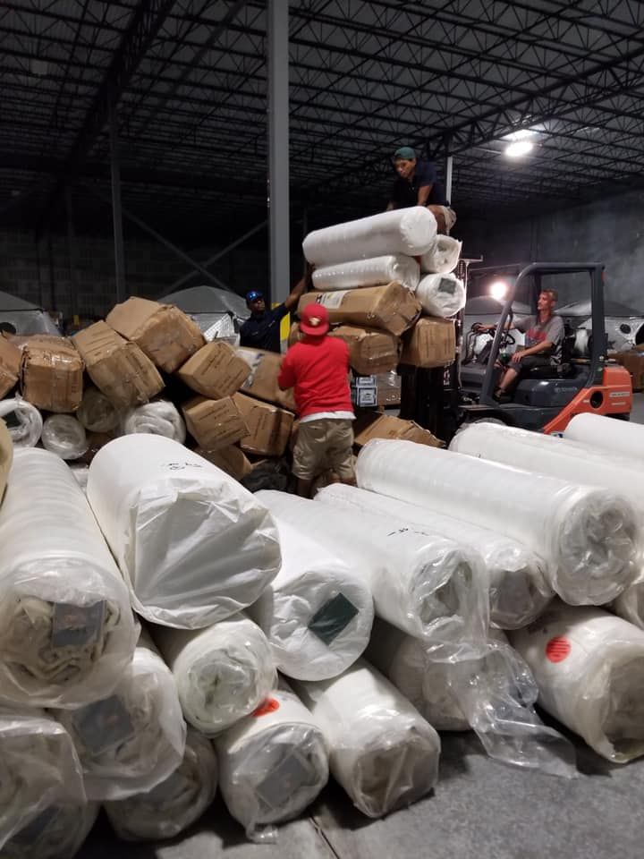 28.4845° N, 81.2519° W A warehouse filled with lots of rolls of plastic and boxes.