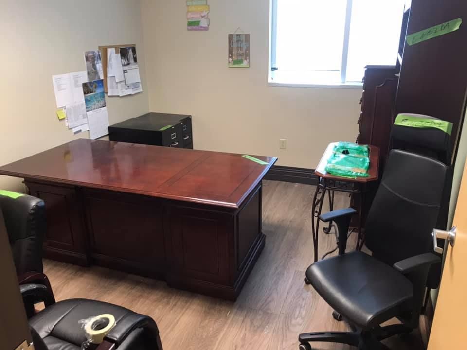 A room with a desk and two chairs in it. 28.4845° N, 81.2519° W