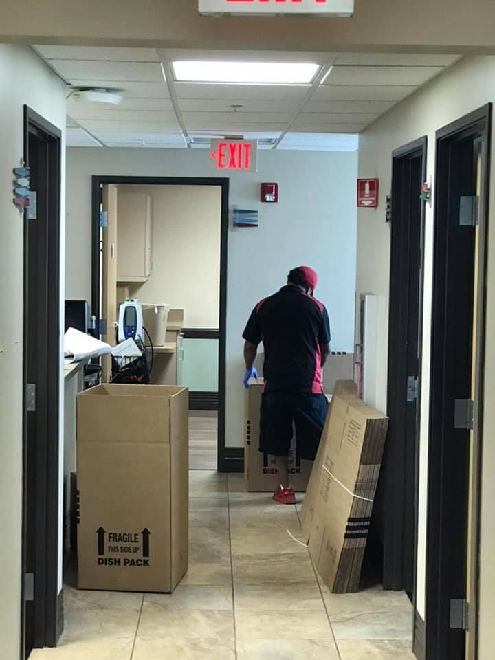 A man standing next to a cardboard box that says fragile on it 28.4845° N, 81.2519° W