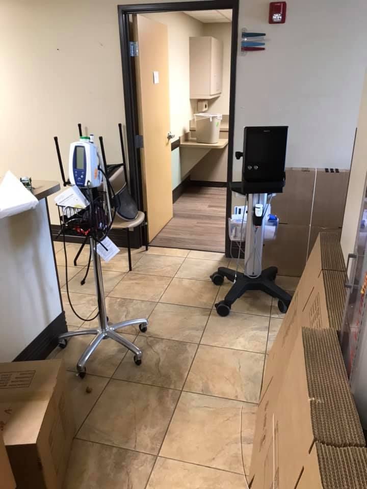 A room with a lot of boxes on the floor and a doorway leading to a bathroom. 28.4845° N, 81.2519° W