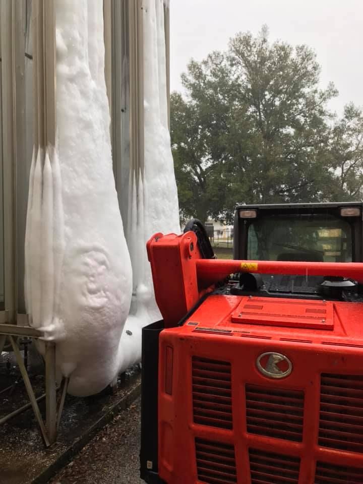 A red truck is parked in front of a large pile of snow. 28.4845° N, 81.2519° W