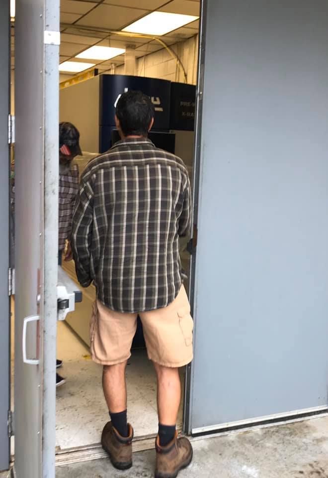 A man in a plaid shirt is standing in a doorway. 28.4845° N, 81.2519° W