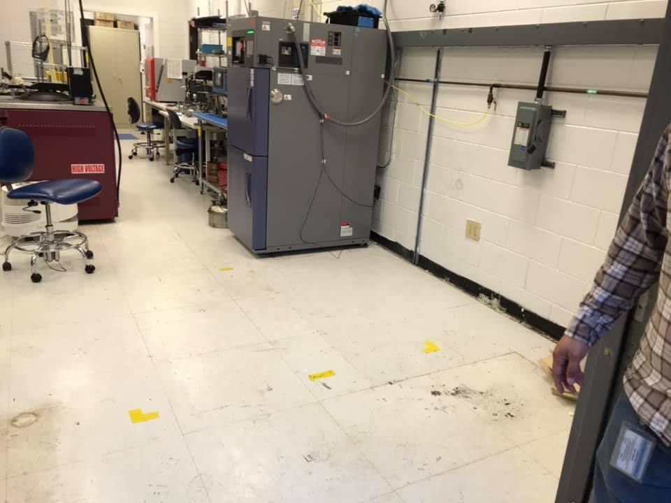 A man in a plaid shirt is standing in a room with a lot of equipment.28.4845° N, 81.2519° W