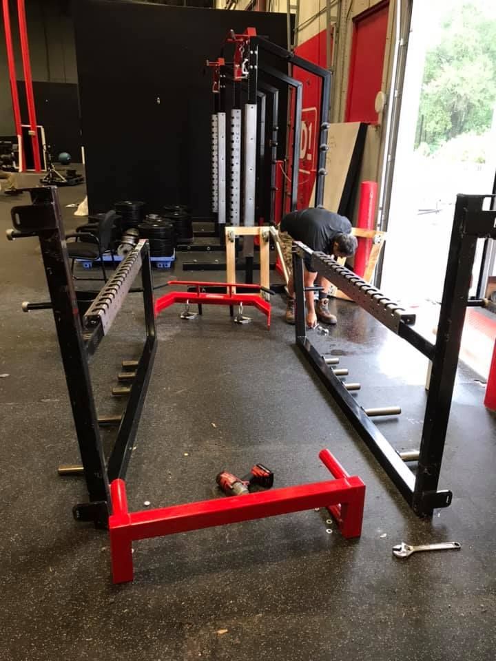 A man is working on a squat rack in a gym 28.4845° N, 81.2519° W