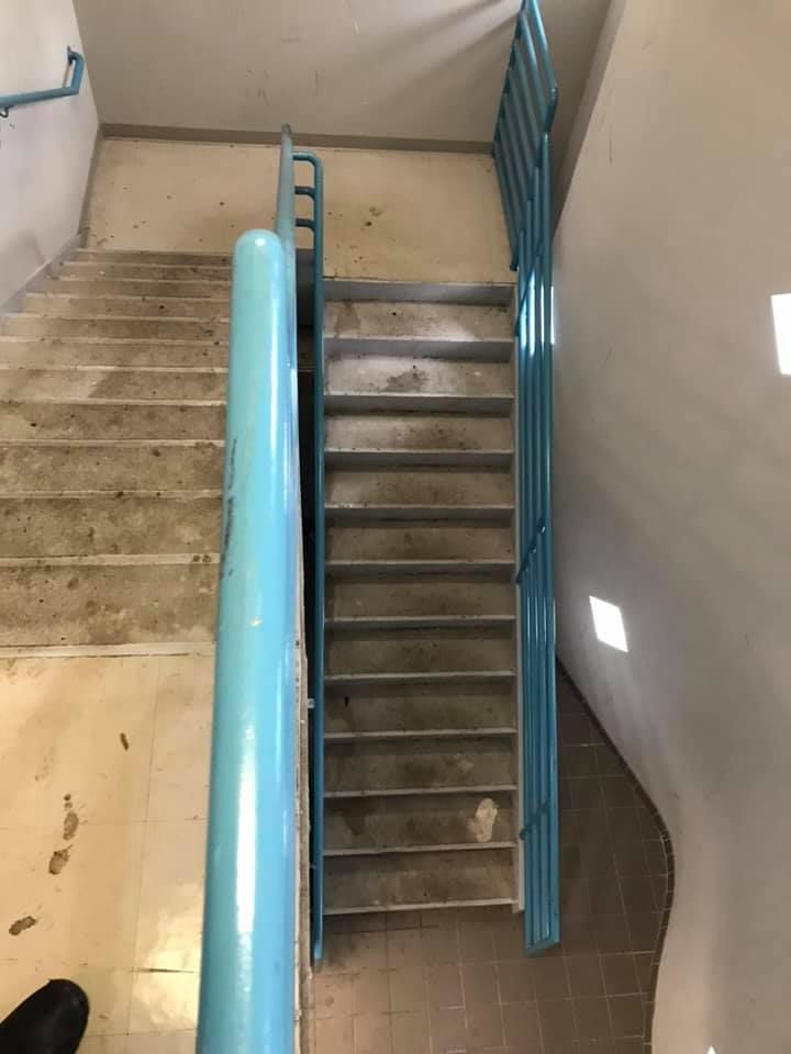 A staircase with a blue railing in a building 28.4845° N, 81.2519° W