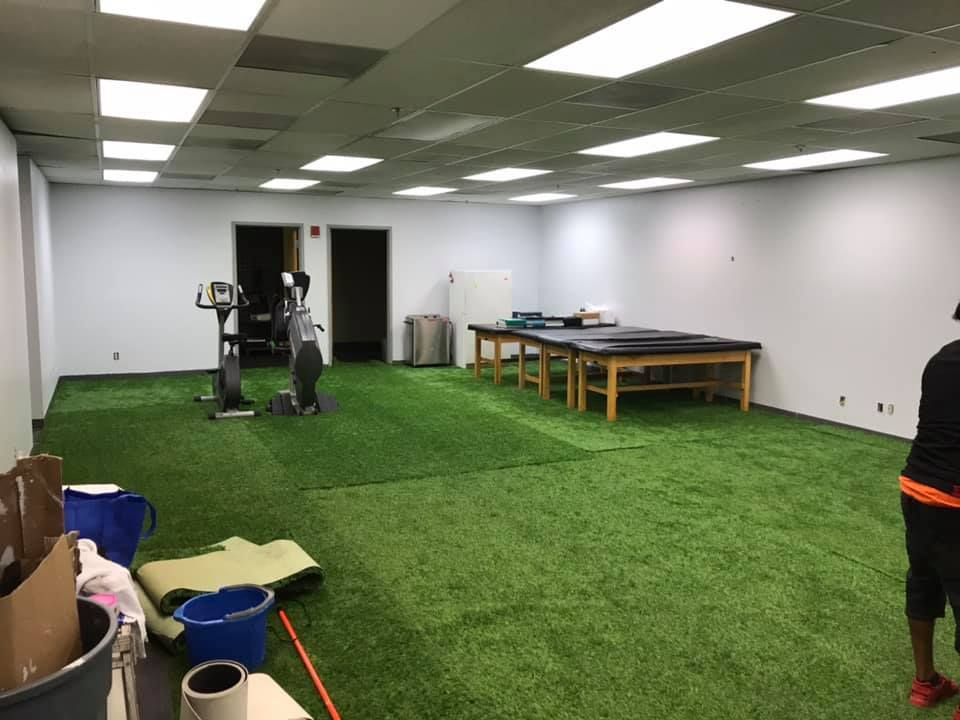 A man is standing in a large room with a green carpet. 28.4845° N, 81.2519° W