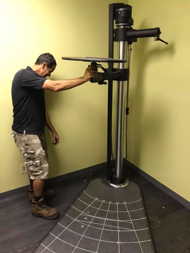 A man is standing in front of a large machine in a room 28.4845° N, 81.2519° W