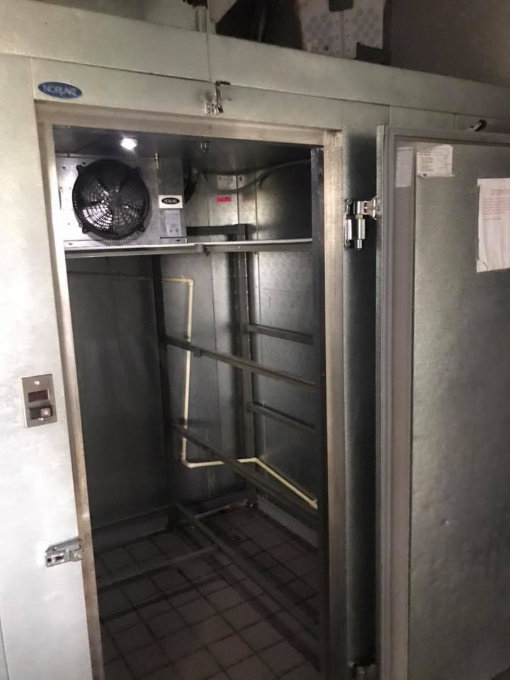 A stainless steel refrigerator with a fan on top of it. 28.4845° N, 81.2519° W