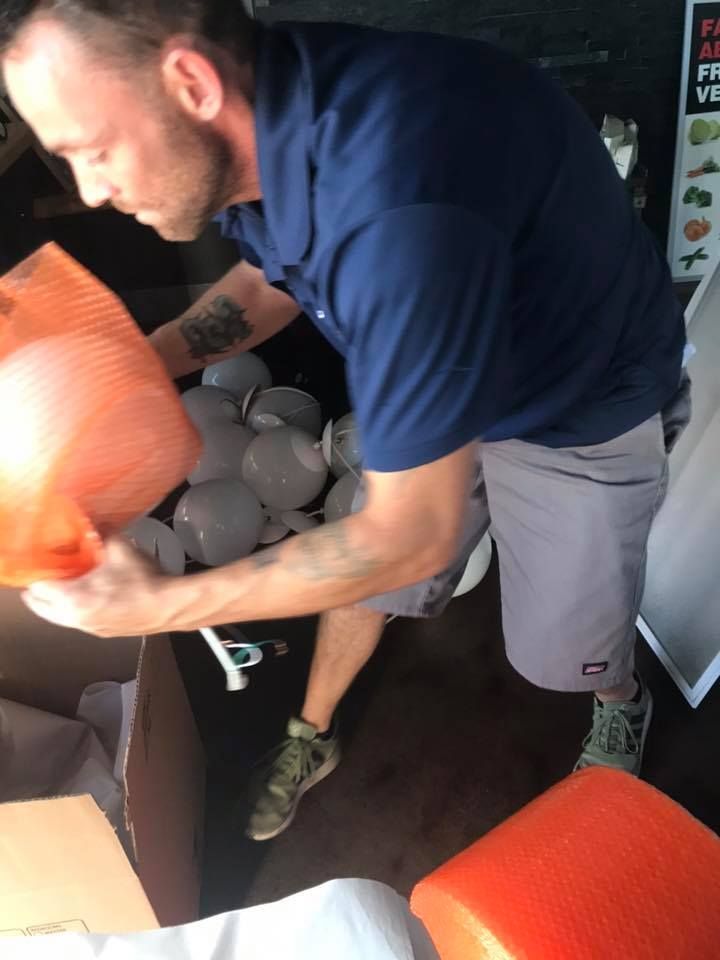 A man in a blue shirt is holding a bag of ice cubes. 28.4845° N, 81.2519° W