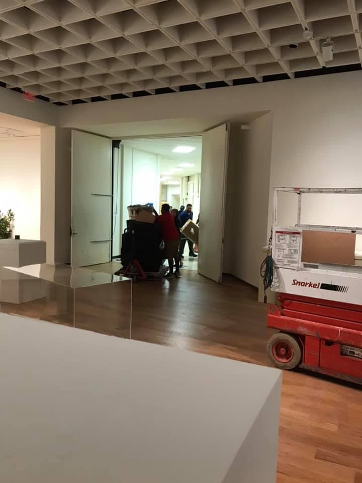 A group of people are standing in a hallway with a machine that says ' scissor lift ' on it 28.4845° N, 81.2519° W