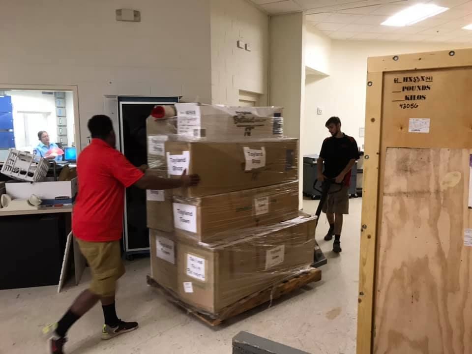 A man in a red shirt is pushing a pallet of boxes 28.4845° N, 81.2519° W