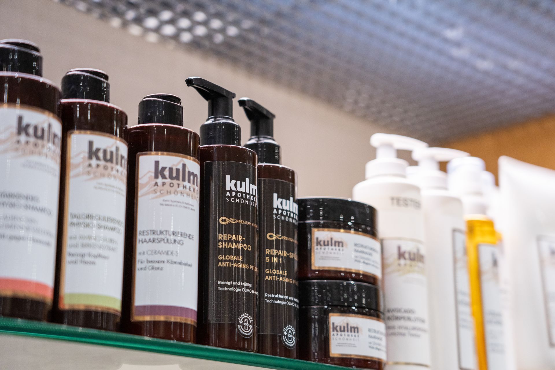 Ein Regal mit braunen und weissen Flaschen und Gläsern mit Kulm-Schönheitsprodukten.