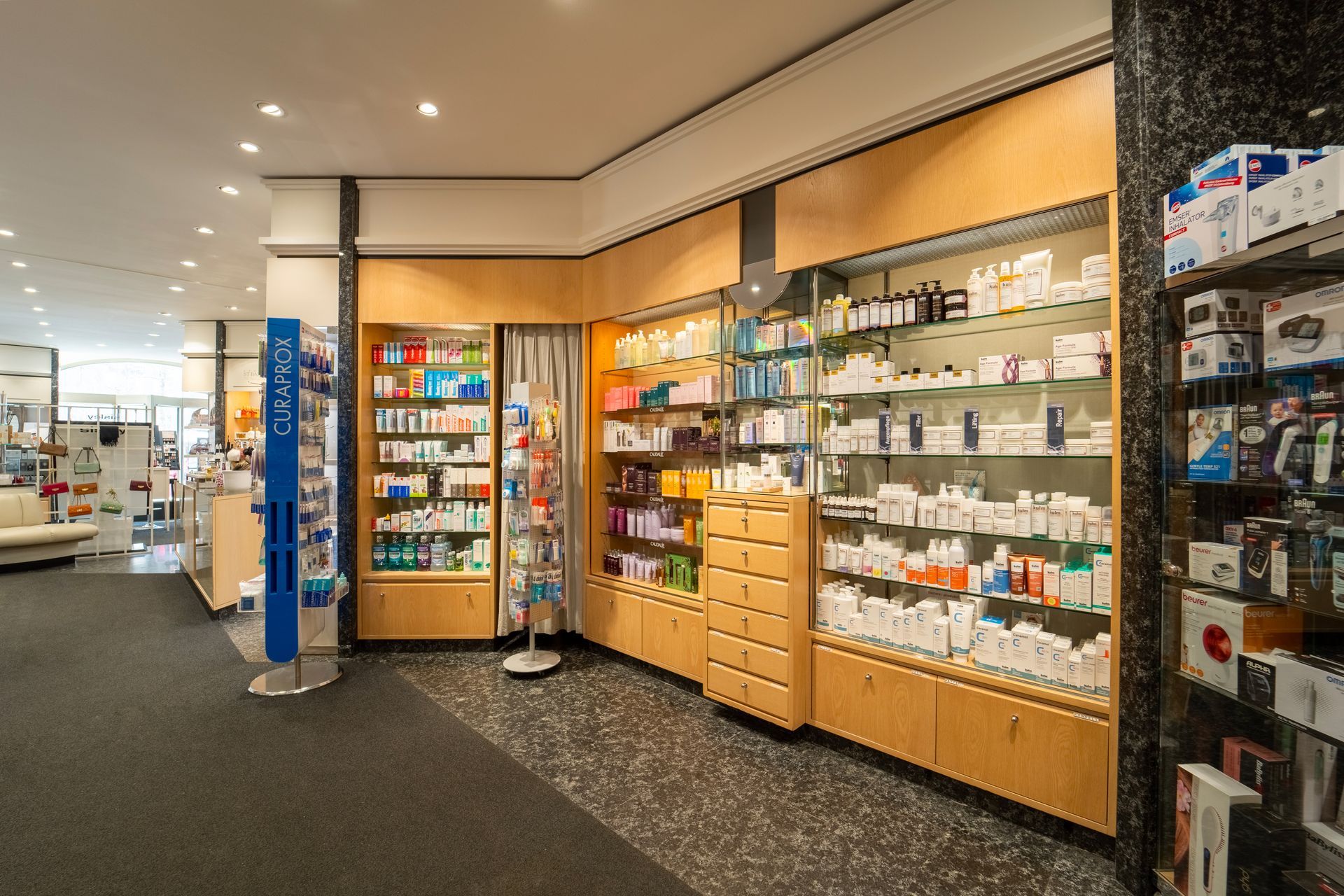 Regale voller verschiedener pharmazeutischer Produkte und Körperpflegeartikel in einer hell erleuchteten Apotheke.