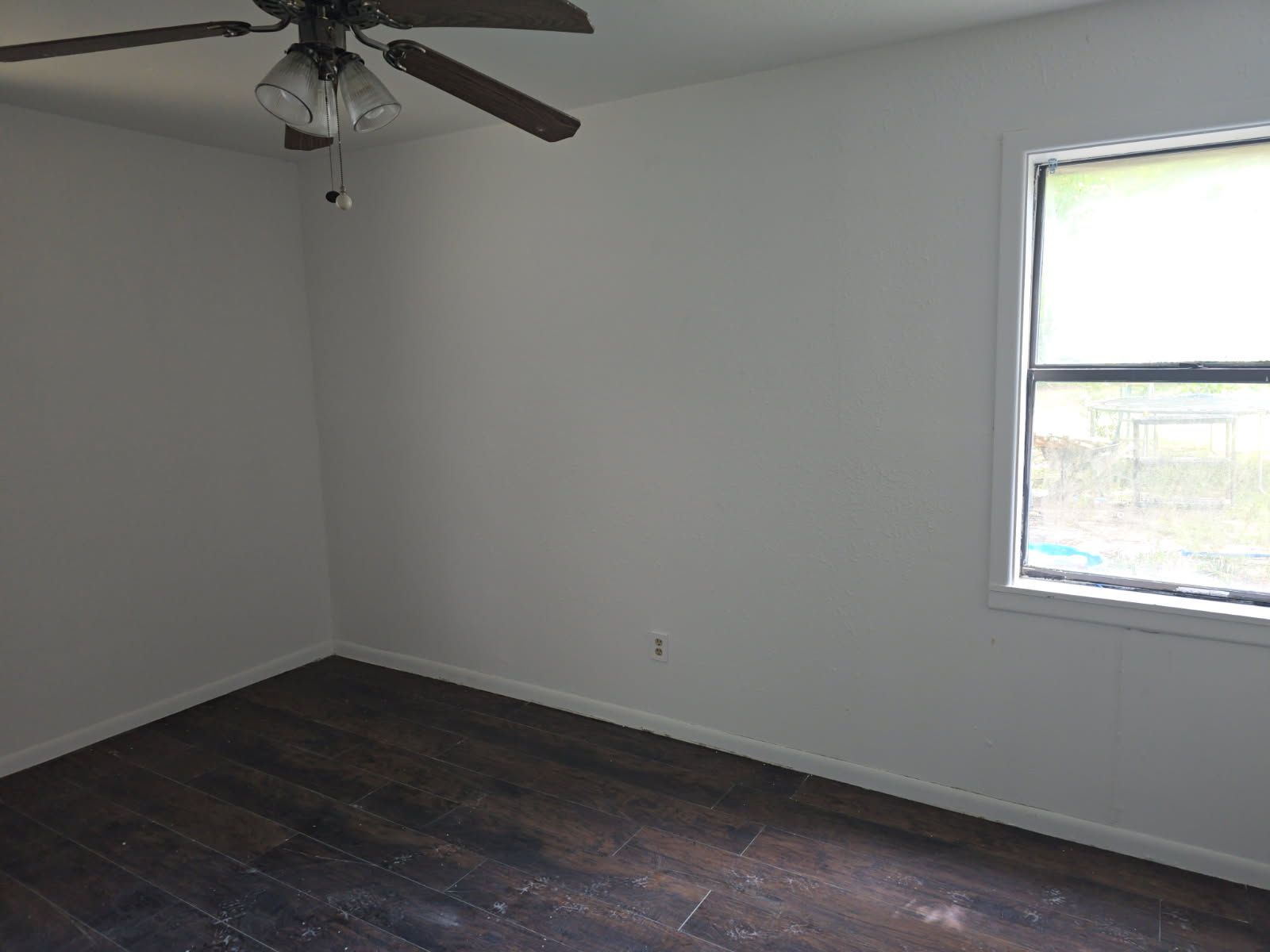 A box is sitting on the floor next to a wooden beam.