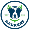 Logo for "The Barkery": a dog-shaped design with hops, collar, and text inside a blue circle.