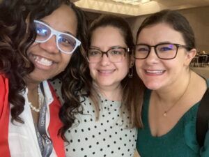 Three women wearing glasses are posing for a picture together.