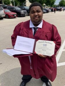 A man in a graduation cap and gown is holding a diploma.