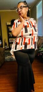 A woman wearing glasses is sitting in a chair in a living room.