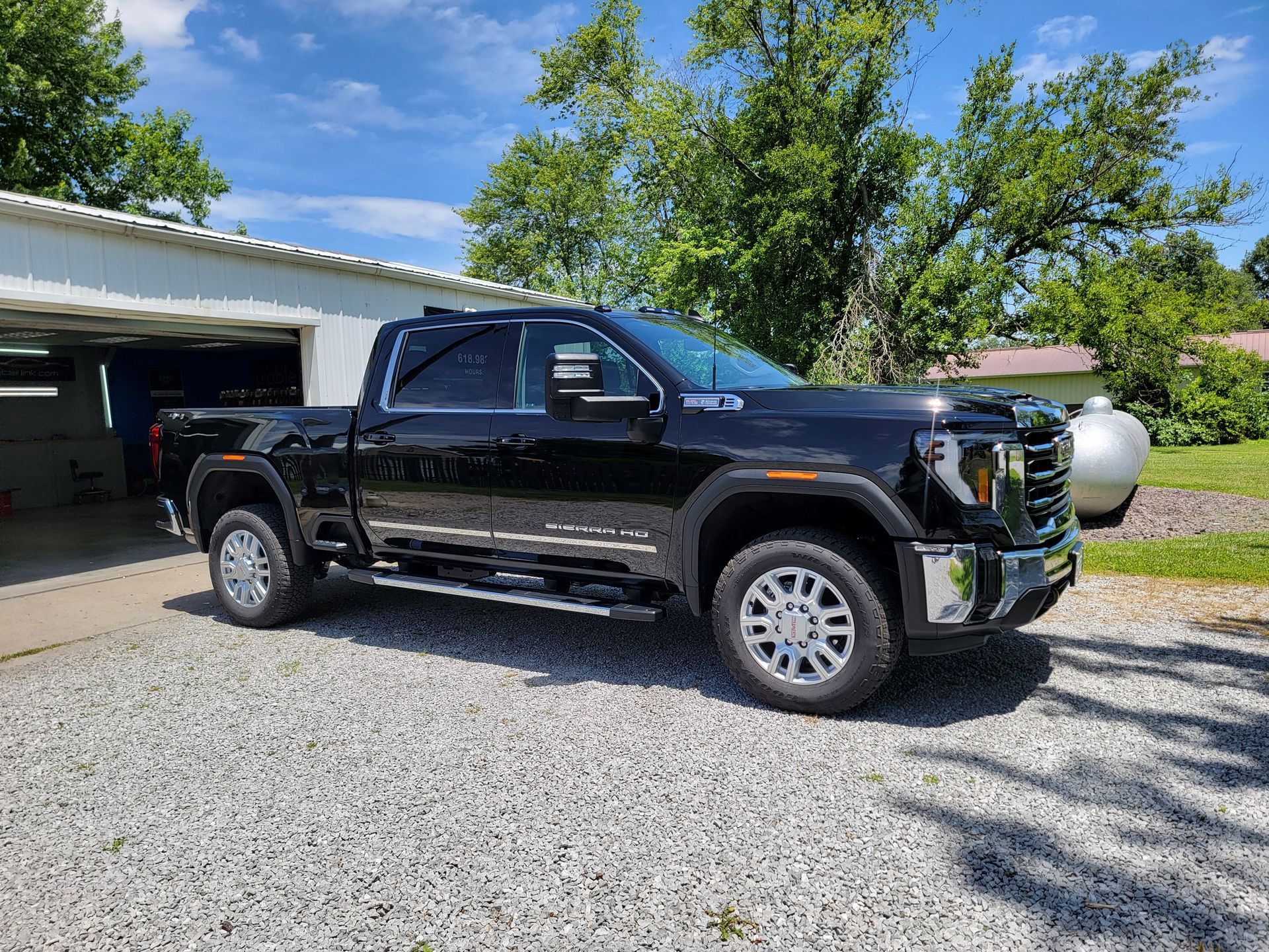 A black pickup truck is parked in front of a garage.