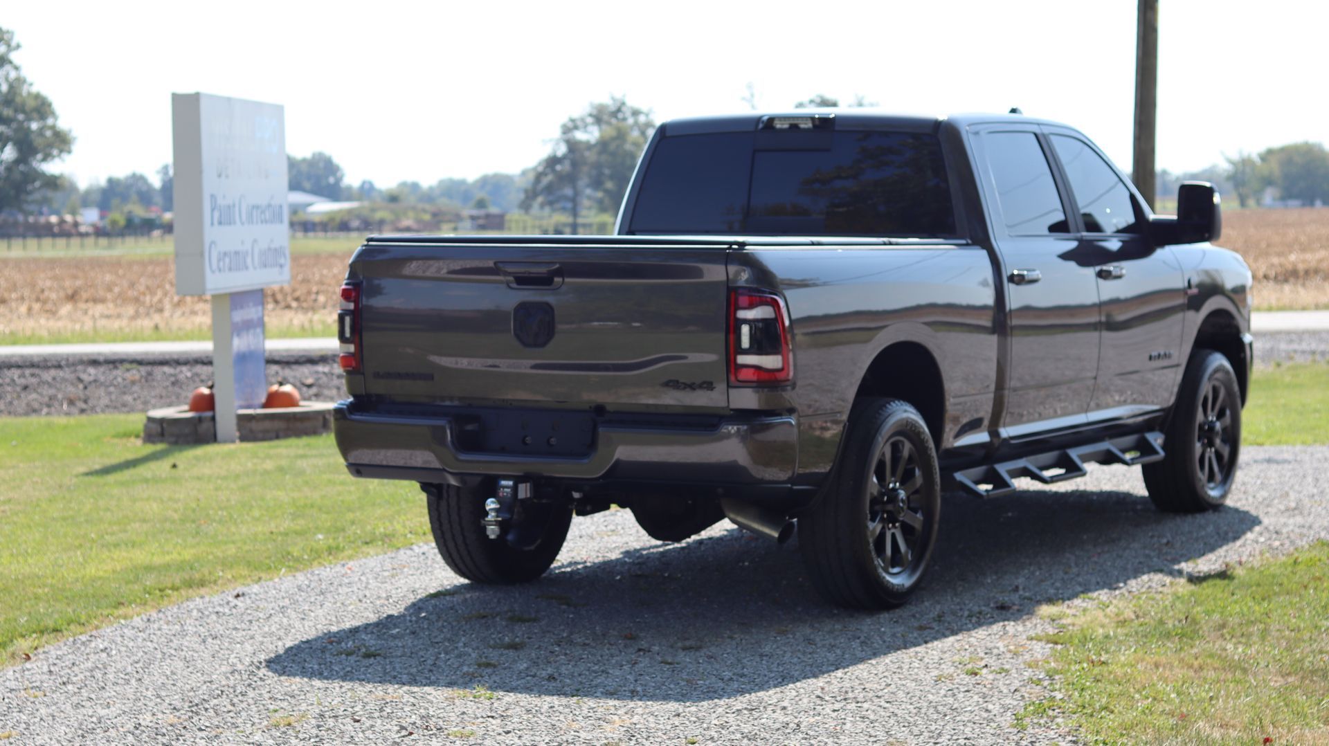 A gray ram truck is parked on a gravel road.