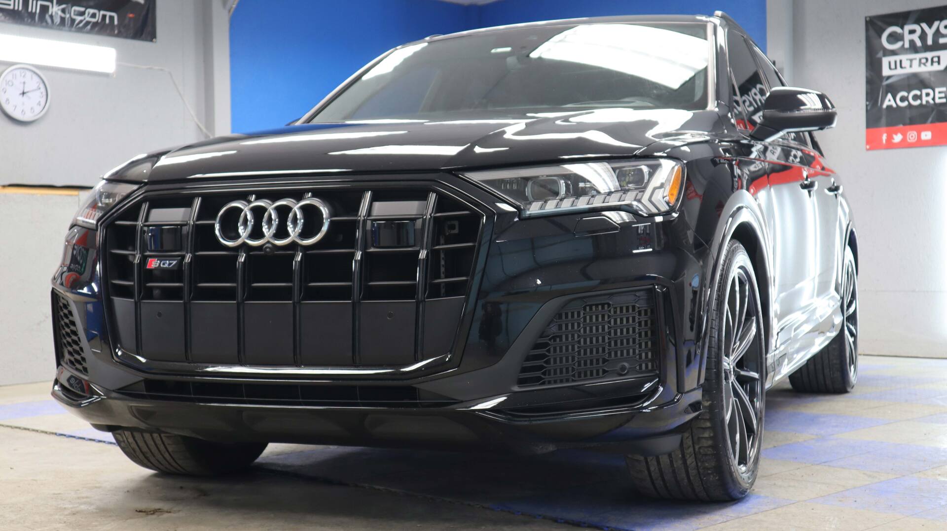 A black audi q7 is parked in a garage.