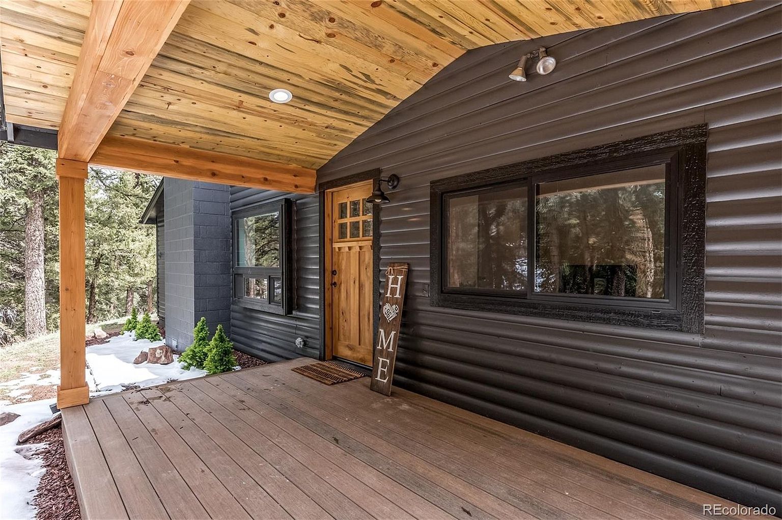 A house with a porch and a sign that says home