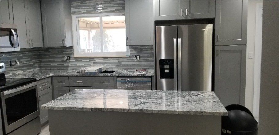 A kitchen with stainless steel appliances and granite counter tops.
