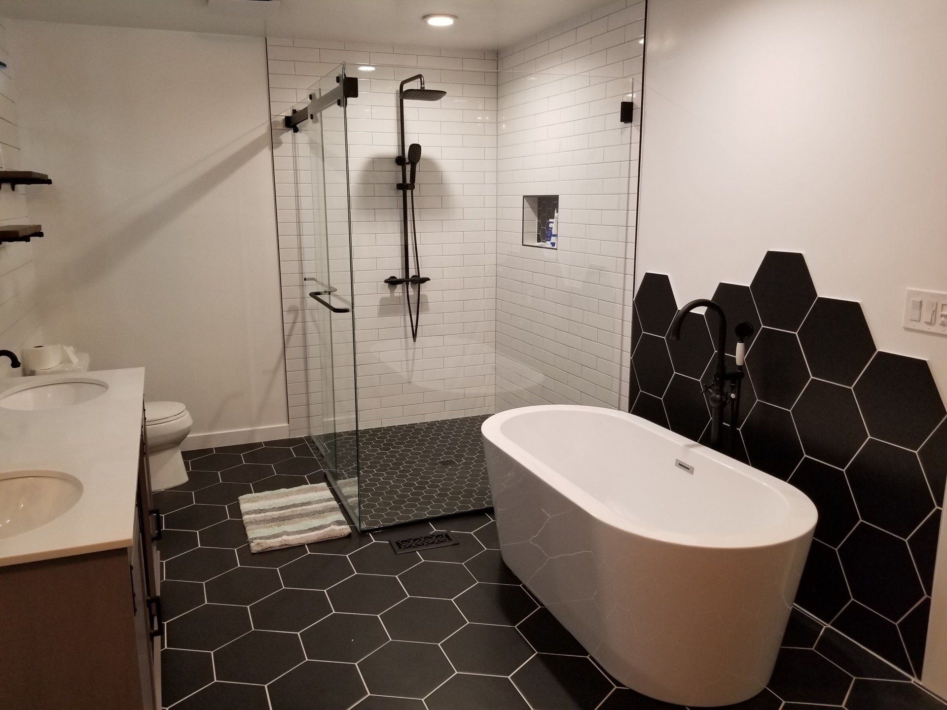 A bathroom with a bathtub , sink , toilet and shower.