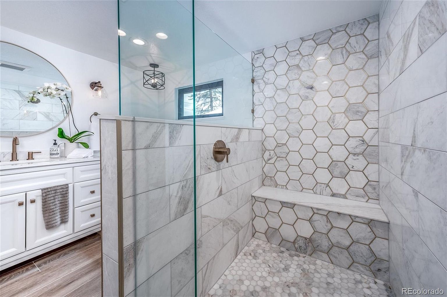 A bathroom with marble tiles and a walk in shower