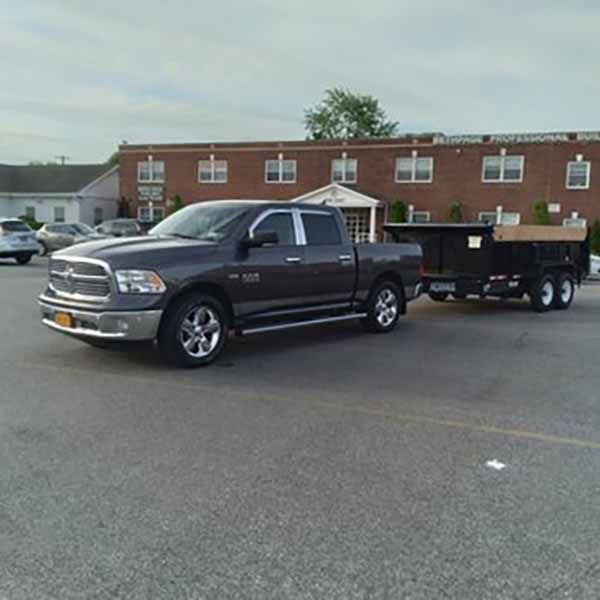 A truck is pulling a trailer in a parking lot