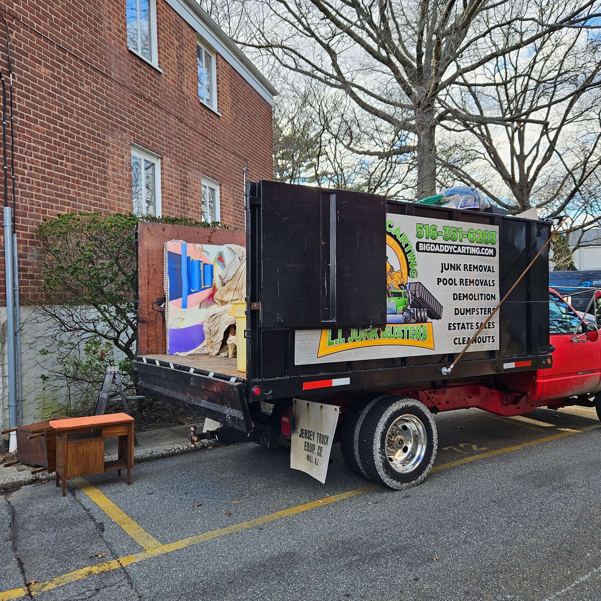 A dump truck is parked in front of a brick building.