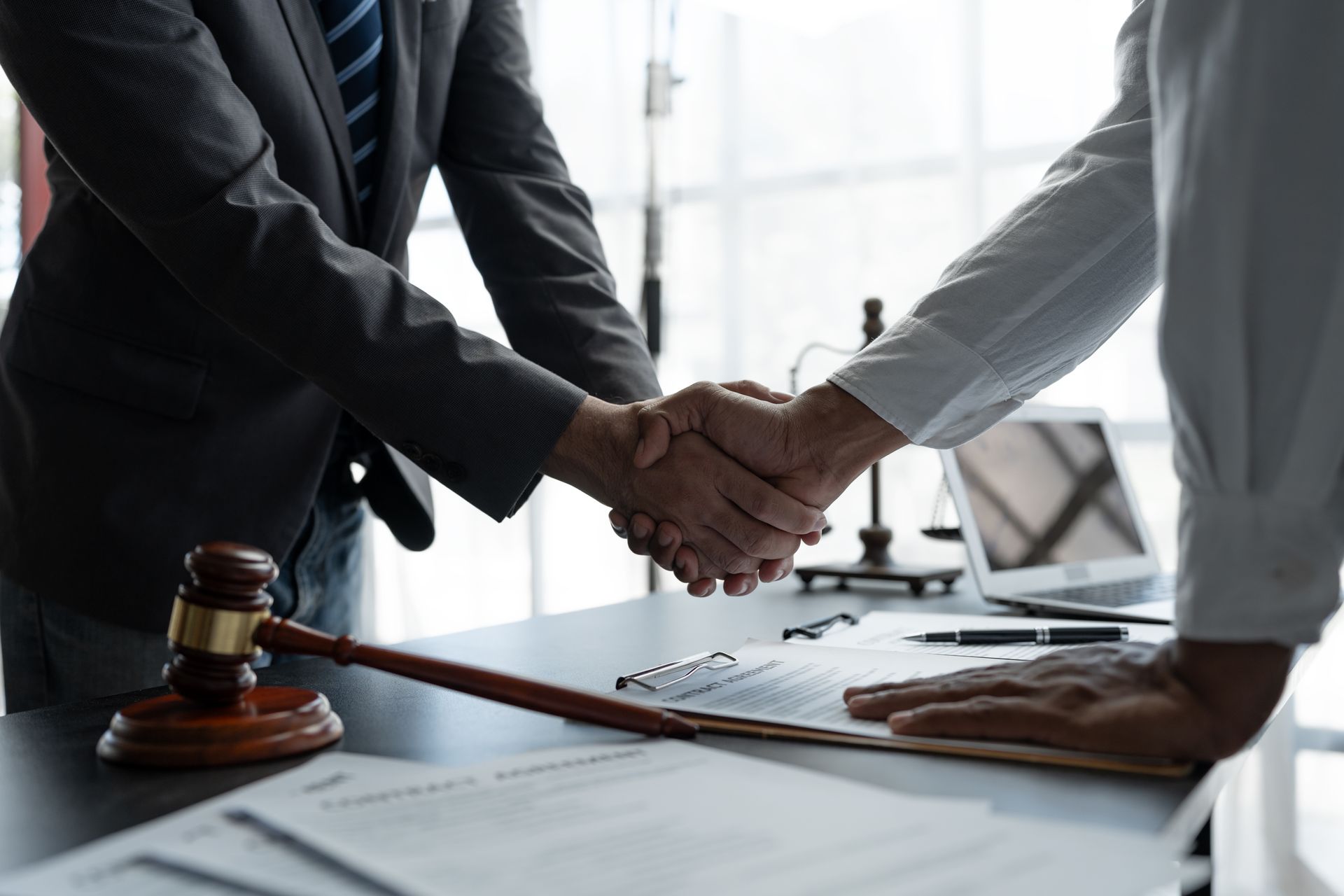 A trust attorney shaking hands with a client in his office.