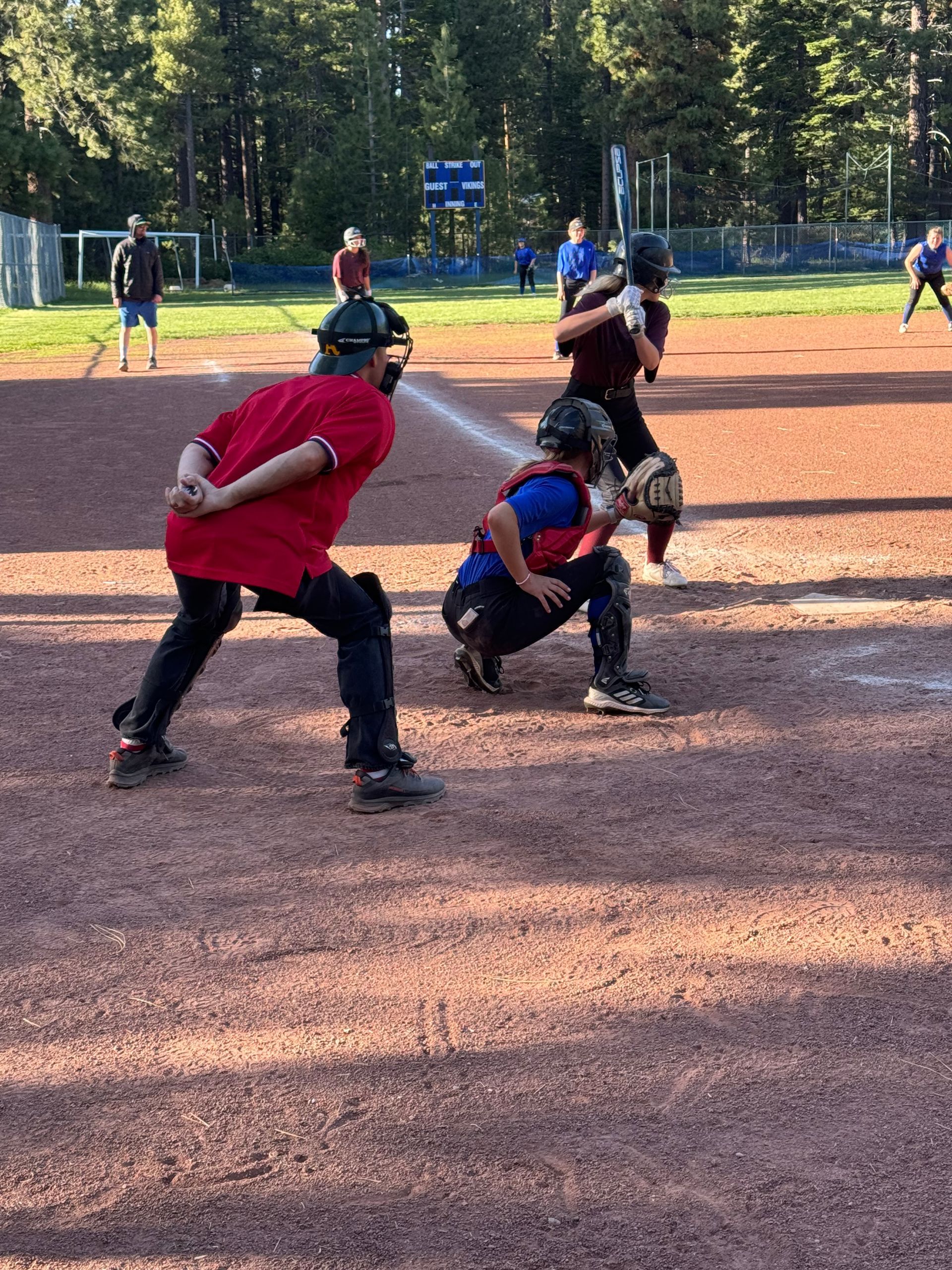 Baseball player sliding into base as another player attempts to catch the ball.