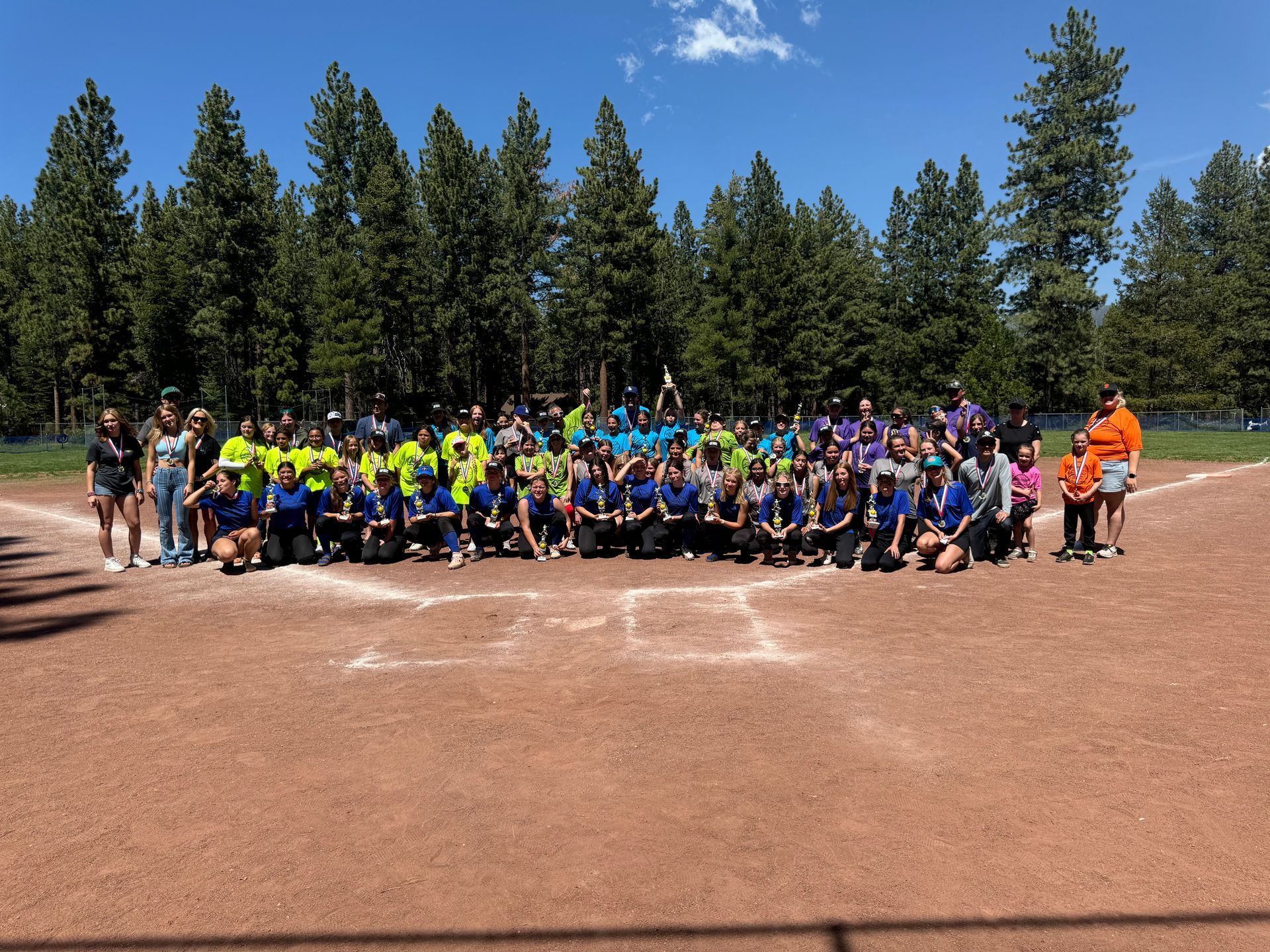 Baseball glove with ball on green grass, with blurred baseballs in the background.