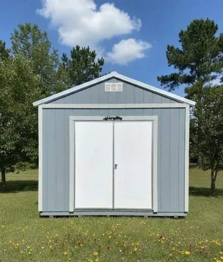 Blue metal shed with white double doors on a grassy lawn under a partly cloudy sky