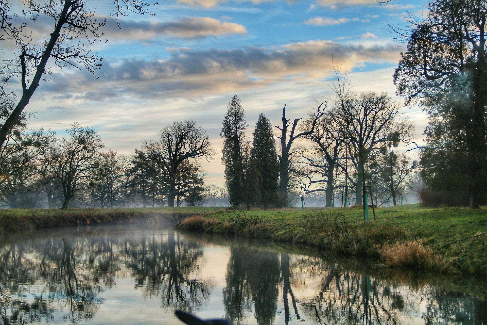 Hiker with orange backpack overlooking mountain range at sunrise.