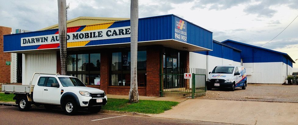 Two Cars Are Parked in Front of a Building That Says Darwin Automobile Care — Darwin Auto Mobile Care in Woolner, NT