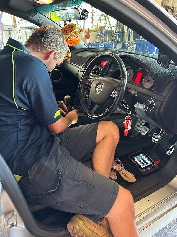 Man is Sitting in the Driver's Seat of a Car — Darwin Auto Mobile Care in Woolner, NT