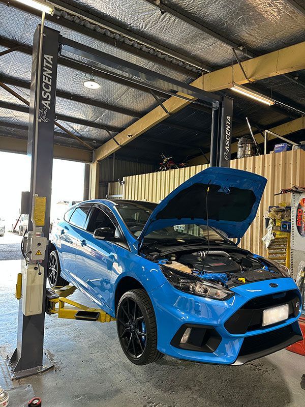 Blue Ford Focus RS is Sitting on a Lift in a Garage — Darwin Auto Mobile Care in Woolner, NT