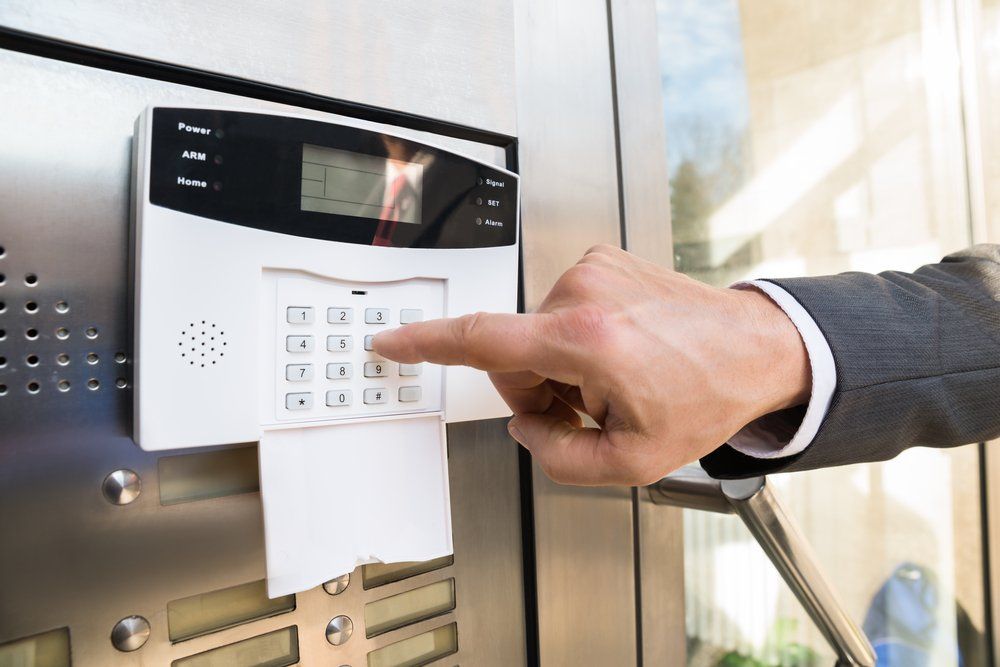 Close-up Of Businessperson Hand Entering Code In Security System — Security System Installations In Byron Bay, NSW