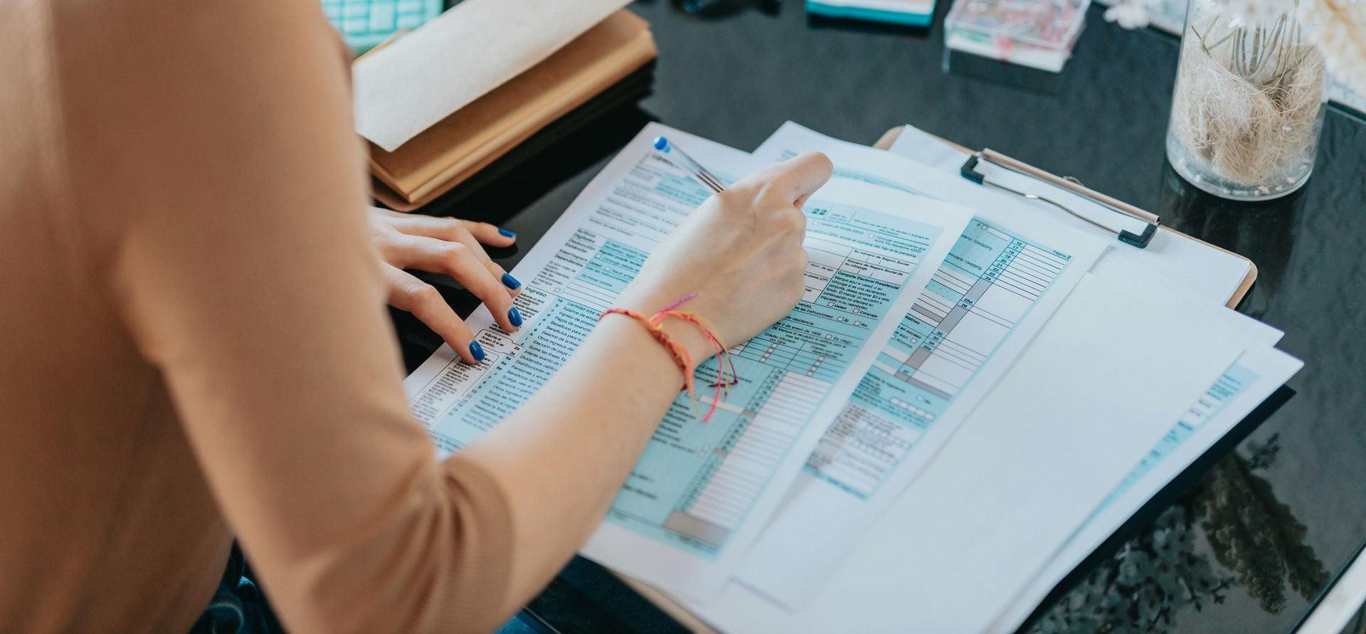 A woman is sitting at a desk looking at papers.
