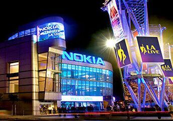 Nokia Theatre L.A. Live at night with bright blue lights and illuminated signs.