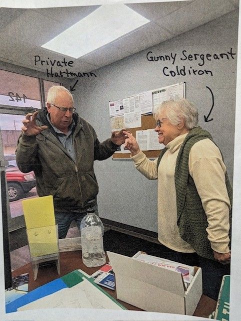 Two older people inside a building, labeled 