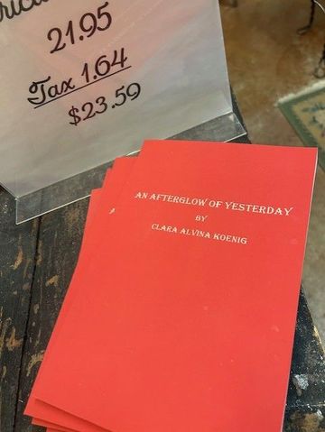 Red book on a table beside a price sign showing $23.59