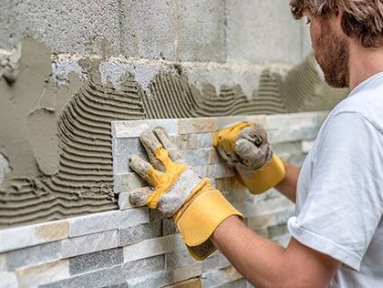 Man Wearing Gloves Placing Tiles — Building Materials in Avenel, NJ