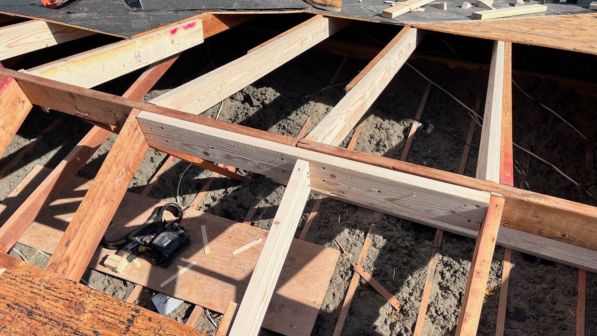 Wooden roof frame under construction with insulation.
