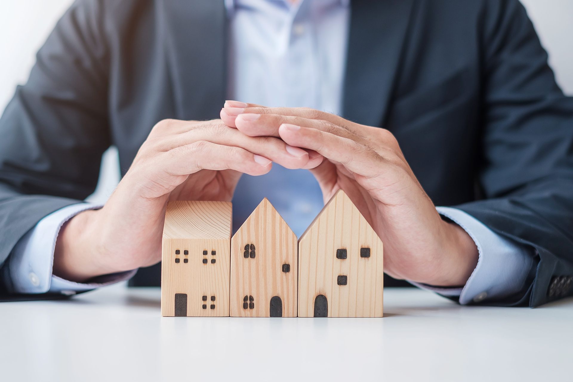 Attorney protecting wooden house models, representing trust property and estate planning